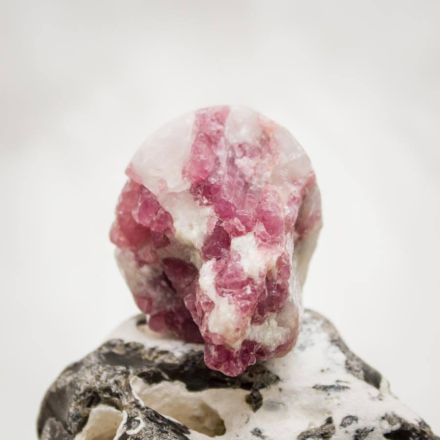 Handgearbeiteter Kristallschädel aus Quarz-Matrixkristall mit rotem Turmalin