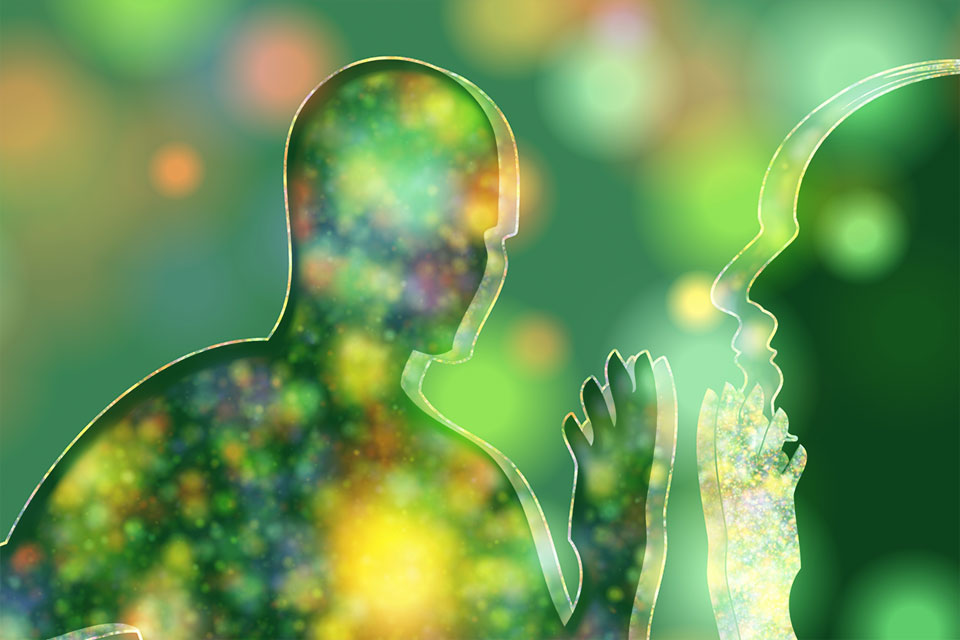 Illustration von Silhouetten von zwei Personen eingehüllt in leuchtende Farbfelder zur Veranschaulichung von Aurasichtigkeit.