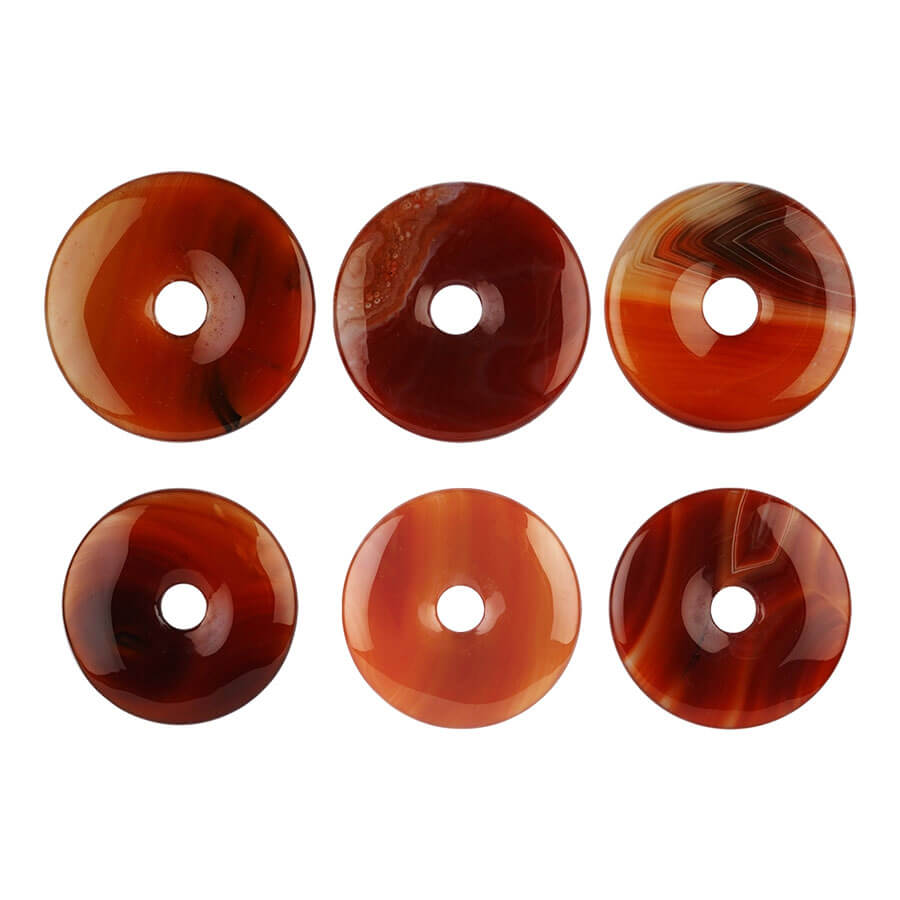 Sechs verschiedene Karneol Donuts mit unterschiedlicher Maserung und Färbung.