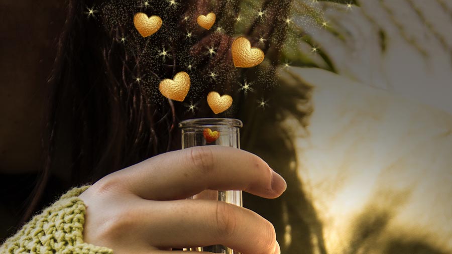 Symbolbild Liebeszauber und Liebestrank. Goldene Herzen fliegen aus einer Flasche.