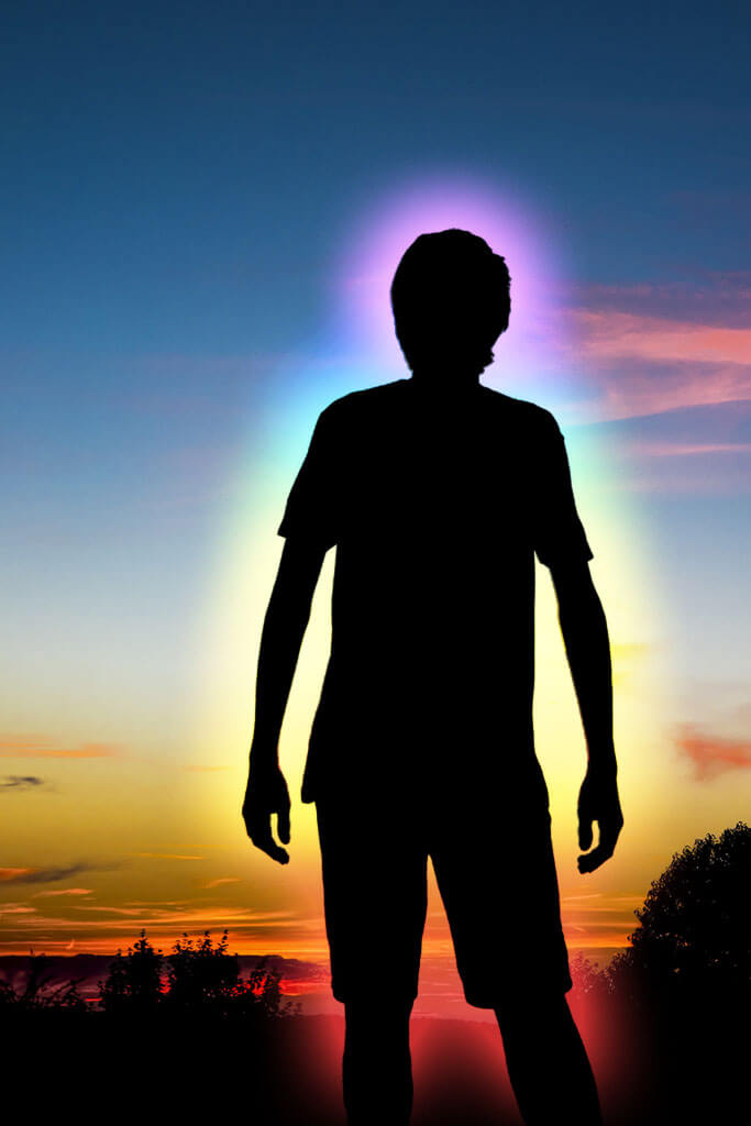 Eine Person im Abendlicht, umgeben vom Farbenschein der eigenen Aura.